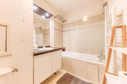 een badkamer met een wastafel, een bad en een douche bij Appartement 39m2 - Free Parking - Rer C - Métro 13-14 - Ascenseur - Easy Check in - in Asnières-sur-Seine