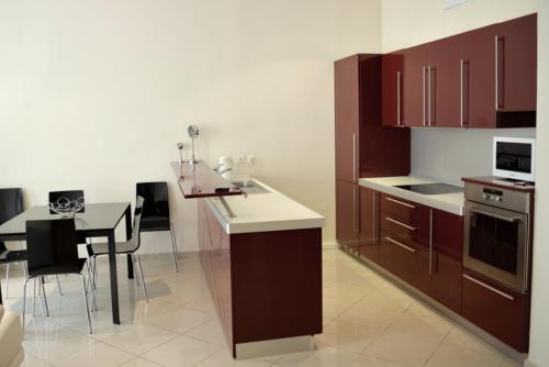 une cuisine avec des placards bruns et une table avec des chaises dans l'établissement Apartment on Rue De France 4, à Nice