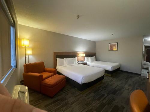 a hotel room with two beds and a chair at Sisk Hotel in Modesto