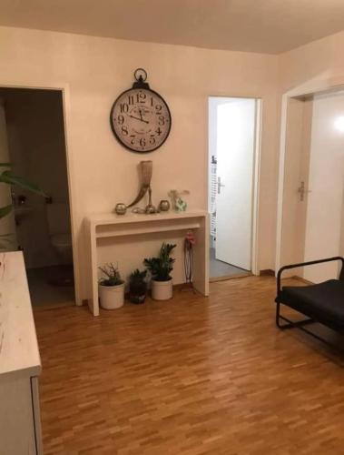 ein Wohnzimmer mit einer Uhr an der Wand in der Unterkunft Quarto lux Centro Geneve 5 estrela in Arni Alp