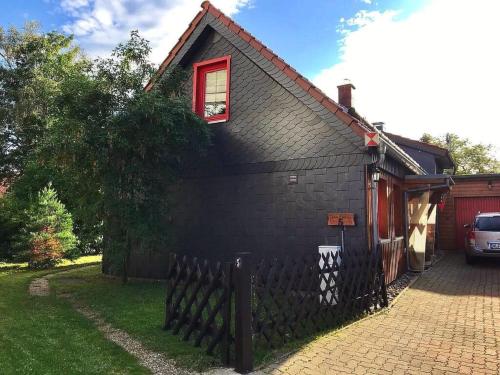 a black house with a window and a fence at Holiday Home Sequoia by Interhome in Hahnenklee-Bockswiese