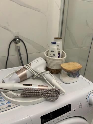 een wasmachine met een borstel en andere accessoires erop. bij Studio apartman MARIA 2 