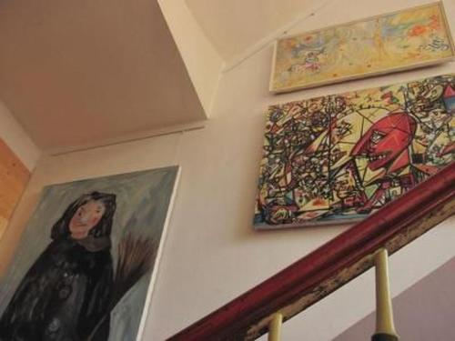 three paintings on a wall next to a staircase at Apartment Kunst Asyl by Interhome in Quedlinburg