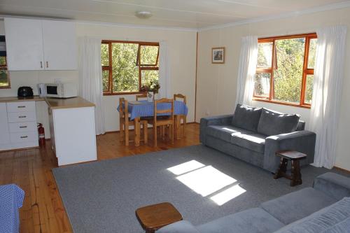 un soggiorno con divano e una cucina di Nibelheim Self Catering Cottage a Hogsback
