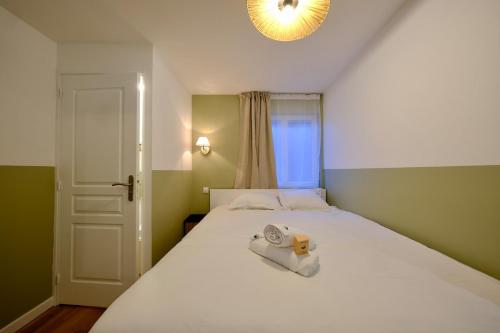 ein Schlafzimmer mit einem Bett und einem Handtuch darauf in der Unterkunft Elbeuf - Appartement moderne pour 4 in Elbeuf