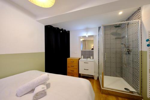 ein Schlafzimmer mit einer Dusche, einem Bett und einem Spiegel in der Unterkunft Elbeuf - Appartement moderne pour 4 in Elbeuf