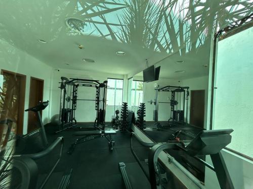 ein Fitnessstudio mit Laufbändern und Crosstrainern in einem Raum in der Unterkunft RM Beach Paradise - Barra Iloa Residense in Barra de São Miguel