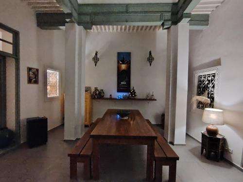 a room with a wooden table in the middle of a room at La Maison des Amis in Fès