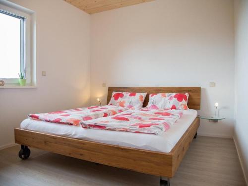 a bedroom with a large bed with red and white pillows at Apartment im Illertal by Interhome in Altenstadt