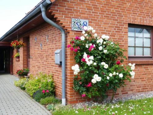 a flower bush on the side of a brick building at Apartment Schwalbenring by Interhome in Rövershagen
