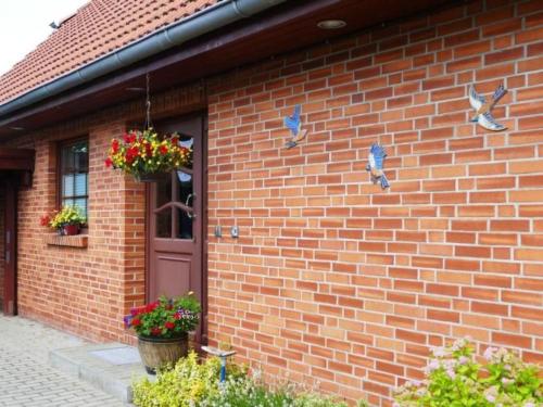 a brick house with birds on the side of it at Apartment Schwalbenring by Interhome in Rövershagen