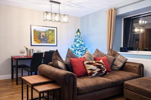 een woonkamer met een bank en een kerstboom bij The Hideaway in Durham
