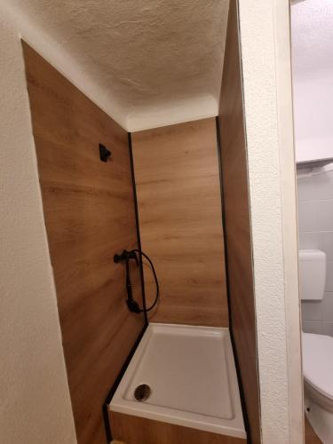 een badkamer met een toilet en een houten deur bij Vienna Gateway - Self Check-In 24 - free parking in Bockfließ