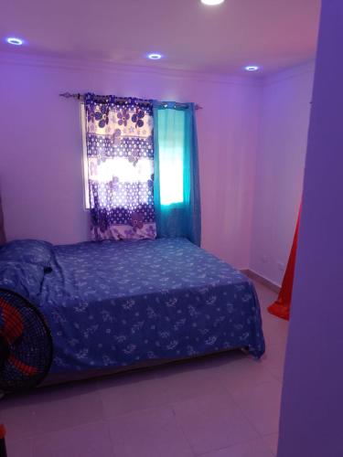 a bedroom with a blue bed with a window at Alojamiento M&M in Los Paredones