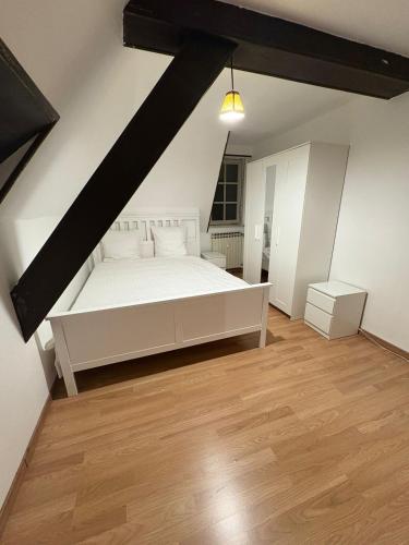 une chambre avec un lit blanc et un parquet dans l'établissement Luxury 3-room house, à Illkirch-Graffenstaden