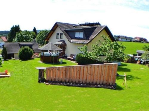 a house on a green lawn with a wooden fence at Apartment Haus-Trapp by Interhome in Unterbernhards