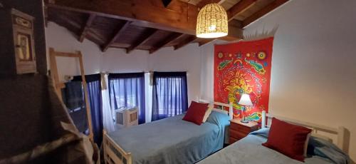a bedroom with two beds and a painting on the wall at Grace’s House, Ezeiza Airport in Monte Grande