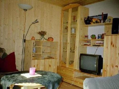 a living room with a tv and a table at Holiday Home mit Bergblick by Interhome in Ilfeld