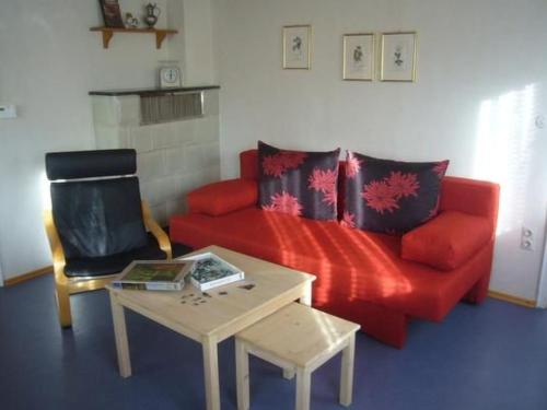 a living room with a red couch and a table at Holiday Home Buschle by Interhome in Tettnang
