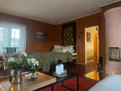 a living room with a bed and a table with flowers at Atelier Torppa in Rovaniemi
