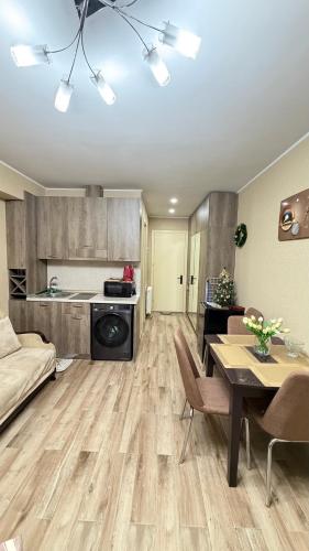 a living room with a table and a kitchen at GL Apartment in New Gudauri Block 3 in Gudauri