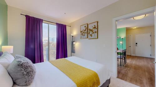 um quarto com uma cama grande e cortinas roxas em Stamford Cozy Apartment with free parking em Stamford