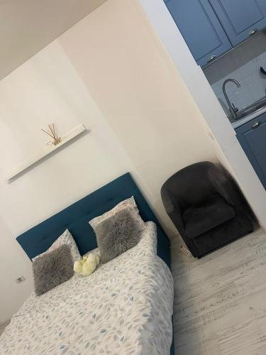 a bedroom with a bed with a blue headboard and pillows at apartament 1 camera in Roşu