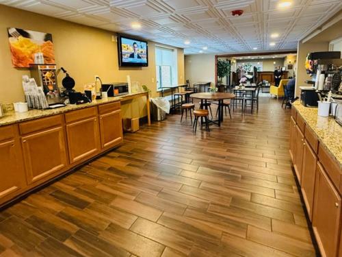 un restaurant avec un comptoir, des tables et des chaises dans l'établissement Wingate by Wyndham Utica, à Utica