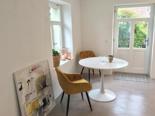 a white table and chairs in a room with a door at Apartment Kleines Loft by Interhome in Gais