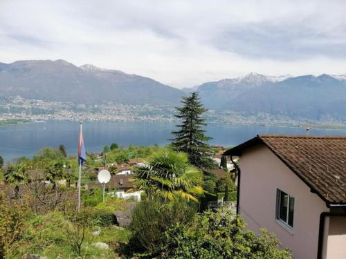 a view of a lake with a house and a flag at Apartment Casa Barbara by Interhome in Piazzogna