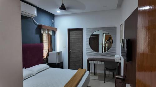 MyCasa في تشيناي: غرفة نوم بها سرير ومكتب ومرآة