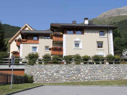 a house on a stone wall with flower boxes at Apartment Aivla by Interhome in Celerina