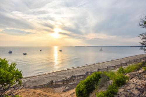 una spiaggia con barche in acqua al tramonto di Stunning Water Views by Private Beach a Eastham