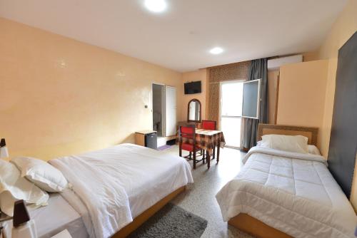 una habitación de hotel con dos camas y una mesa en HOTEL VELLEDA, en Rabat