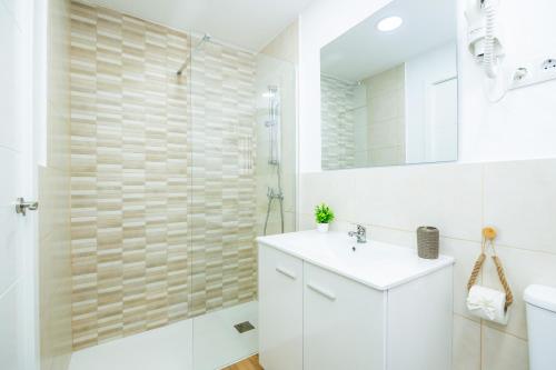 ein weißes Badezimmer mit Waschbecken und Dusche in der Unterkunft Gran Sol Family 6 in Cala Ferrera