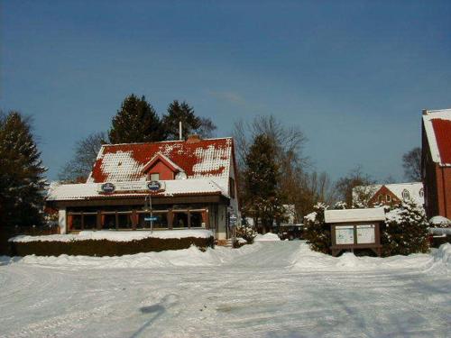 ein Haus ist mit Schnee bedeckt in einem Hof in der Unterkunft Hotel Pension Haus Irene in Hohwacht