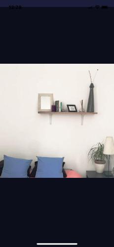 a bedroom with a bed and a shelf on the wall at Petit studio haussmannien in Marseille