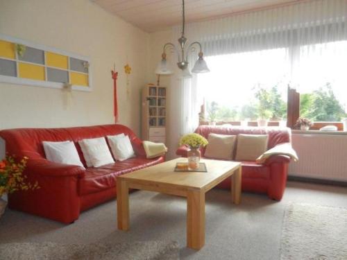 a living room with a red couch and a coffee table at Apartment im Teutoburger Wald by Interhome in Schieder