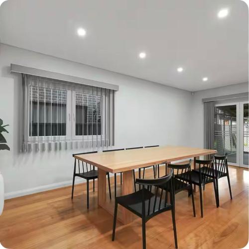 a dining room with a wooden table and black chairs at Lovely Duplex in Cabramatta West 4 bedrooms in Cabramatta Station