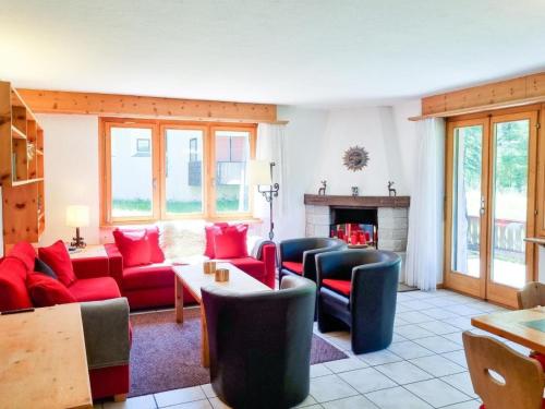 a living room with red furniture and a fireplace at Apartment Curtins16 by Interhome in Pontresina