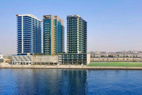 a group of tall buildings next to a body of water at The First Collection Waterfront, Dubai, a Tribute Portfolio Hotel in Dubai