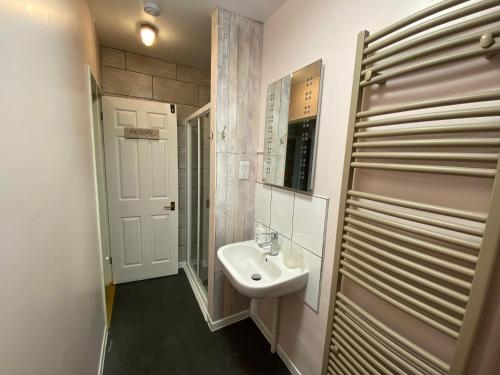 ein weißes Badezimmer mit Waschbecken und Spiegel in der Unterkunft Bungalow in Badsey, north of Cotswolds in South Littleton