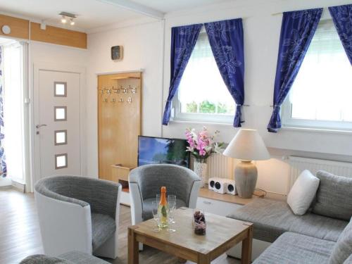 a living room with blue curtains and a couch at Apartment Vulkaneifel by Interhome in Daun