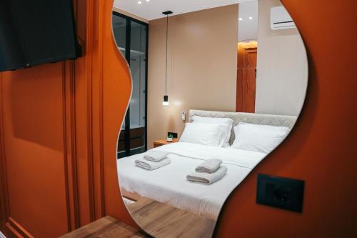 een slaapkamer met een bed met een spiegel ernaast bij Amarus Apartments in Gjirokastër