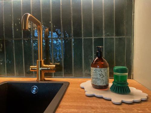 a bottle of soap sitting on a counter next to a sink at Atelier Torppa in Rovaniemi