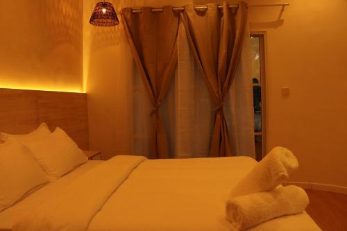 a bedroom with a bed with a teddy bear on it at Cocomero Inn in Fulidhoo