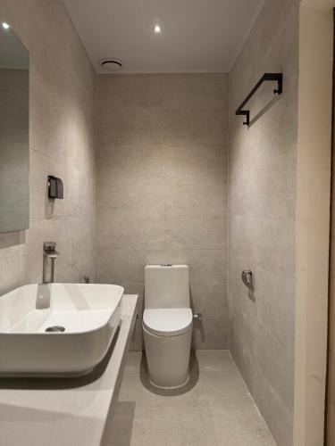 a bathroom with a white toilet and a sink at Cocomero Inn in Fulidhoo