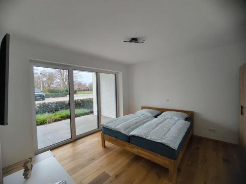 a bedroom with a bed and a large window at SeeZeitApartments Whg 27 in Lembruch