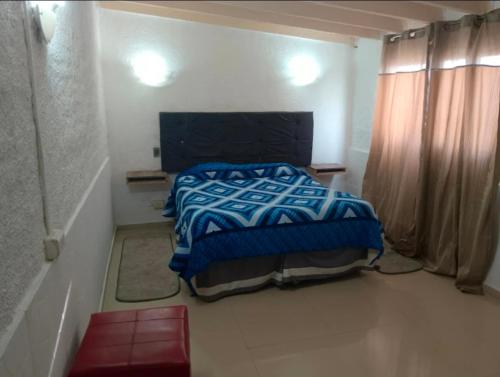 a bedroom with a bed with a blue comforter at Cabañas las vegas in San Antonio