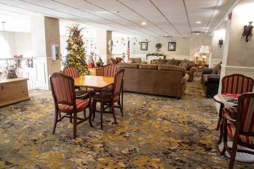 a living room with a table and chairs and a christmas tree at Hotel Grand Victorian in Branson